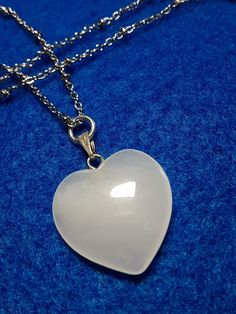 A white riverstone Heart necklace - Stainless steel cable chain with spaced rondelles, necklace included (19- 20 in) hangs from a a silver bail. Heart  is 3/4 in by 1 inch. Includes a lobster claw clasp. Sold individually. Hypoallergenic Heart Shaped Stainless Steel Necklace, White Stainless Steel Heart Pendant Jewelry, White Pendant Necklace For Valentine's Day, White Stainless Steel Jewelry With Heart Charm, White Stainless Steel Necklaces For Anniversary, White Stainless Steel Necklace For Anniversary, White Stainless Steel Pendant Necklace, White Heart Charm Necklace With Round Pendant, White Heart Pendant Necklace With Adjustable Chain