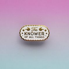 the knower of all things lapel badge on a pink and blue background with white lettering