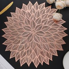 a pink paper doily sitting on top of a table next to flowers and scissors