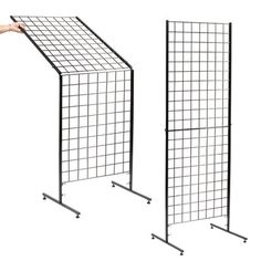 two black metal grids with one holding the other's hand and pointing at it