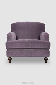 a purple chair sitting on top of a white floor next to a gray wall and wooden legs