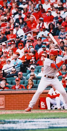 a baseball player holding a bat on top of a field in front of a crowd