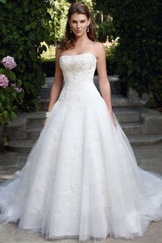 a woman in a white wedding dress posing for the camera with her hands on her hips