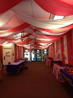 an indoor event with red, white and blue decorations on the ceiling is ready for guests to arrive