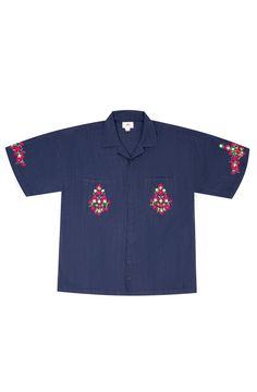 A dark blue cotton embroidered shirt featuring vibrant, plant-inspired embroidery reminiscent of A.R. Chughtai’s art on pockets and sleeves. Relaxed Fit Cotton Camp Shirt With Floral Embroidery, Blue Shirt With Floral Embroidery And Relaxed Fit, Blue Floral Embroidered Shirt With Relaxed Fit, Blue Floral Embroidery Shirt With Relaxed Fit, Blue Cotton Shirt With Floral Embroidery, Navy Embroidered Cotton Tops, Indigo Cotton Top With Floral Embroidery, Indigo Cotton Tops With Floral Embroidery, S Art