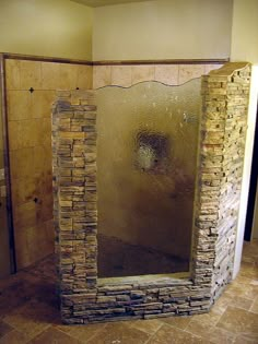 a bathroom with a stone shower and tiled floor