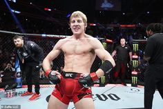 a man standing in the middle of a ring with his hands on his hips and wearing boxing gloves