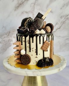 a decorated cake with chocolate, cookies and other items on it sitting on a table