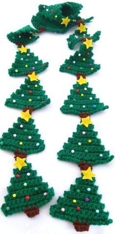 crocheted christmas tree ornaments are arranged in rows on a white surface with yellow stars