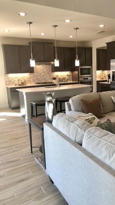 a living room filled with furniture next to a kitchen