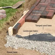 bricks are laid on the ground to form a walkway for an outdoor area with gravel and grass