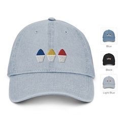 a blue hat with three different colored cupcakes embroidered on the front and sides