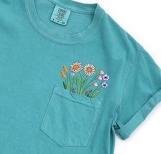 Comfort Colors Embroidered Crewneck Wildflower pocket Tshirt, Embroidered Flower shirt, Flower Boho Shirt, Gift for Her, MADE IN USA. PLEASE NOTE THAT THE PICTURES ON THE LISTING ARE SAMPLES ONLY. If interested in adding embroidery to the sleeve please go to this listing: https://www.etsy.com/listing/1674502020 Because it is made to order, we don't accept the return or exchange unless we make a mistake We are unable to replace or refund purchases based on the color and the font selections. Pleas Spring Blue Tops With Side Pockets, Green Spring T-shirt With Pockets, Green Pocket T-shirt For Spring, Spring T-shirt With Pockets And Relaxed Fit, Green T-shirt With Pockets For Spring, Spring Crew Neck Shirt With Pockets, Green Cotton Shirt With Floral Embroidery, Spring Relaxed Fit T-shirt With Pockets, Relaxed Fit T-shirt With Pockets For Spring