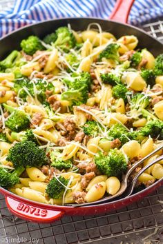 a skillet filled with pasta and broccoli on top of a cooling rack