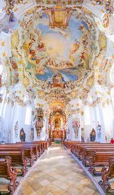 the inside of a church with painted ceilings and pews