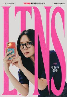 a woman with glasses holding up a cell phone in front of a pink poster that reads, twins