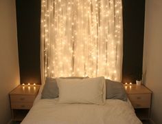 there is a bed that has lights on the wall behind it