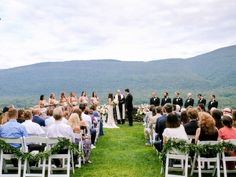 a couple getting married at the end of their wedding ceremony with mountains in the background