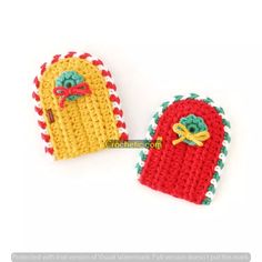 two crocheted mittens with bells on them sitting next to each other in front of a white background