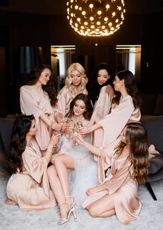 a group of women in pink robes sitting around each other