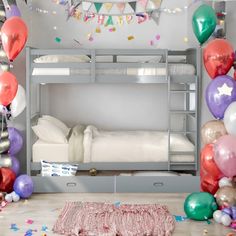 a bunk bed with balloons and confetti around it