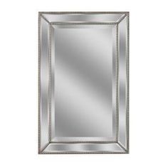 a large silver framed mirror on a white wall with beading around the edges and bottom edge