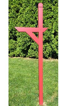 a red wooden cross sitting in the grass