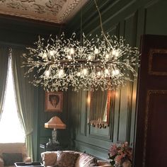 a living room filled with furniture and a chandelier hanging over the couches