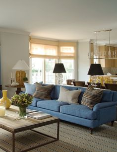 a living room filled with blue couches and lamps