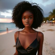 a woman standing on top of a beach next to the ocean