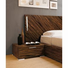 a bed with a wooden headboard and night stand next to it on a hard wood floor