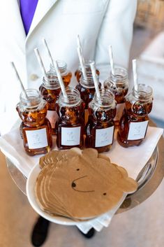 there is a tray with honey jars and napkins on it, as well as paper tags