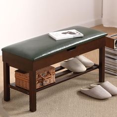 a wooden bench sitting on top of a rug next to a pile of pillows and slippers