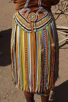 a woman wearing a multi colored skirt with fringes