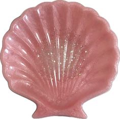 a pink scallop shell shaped dish with gold glitters on the bottom and sides