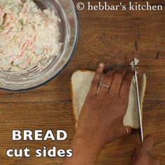 a person cutting bread with a pair of scissors next to it on a wooden table