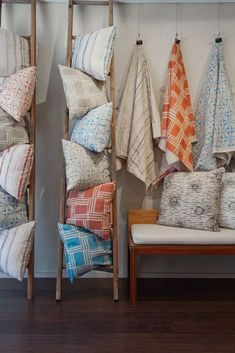 several different colored pillows hanging on a wall