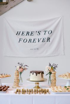 there's to forever sign hanging over a table with desserts and pastries