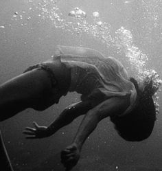 a person swimming in the water with their feet up and his head above the water's surface