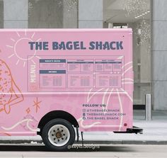 a pink food truck parked in front of a building