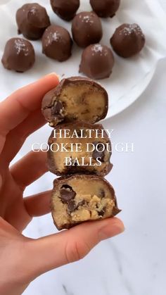 someone is holding up some chocolate covered balls on a plate with the words healthy cookie dough balls in front of them