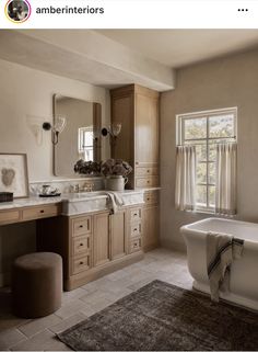 a bath room with a tub a sink and a mirror on the wall next to a window