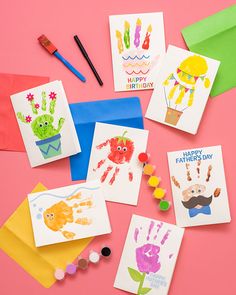 handprints and cards on a pink background with colored envelopes, pencils and markers