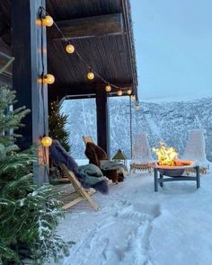 a covered porch with chairs and a fire pit in the middle of it on a snowy day