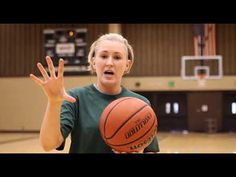 a woman holding a basketball in her right hand and making a weird face with her left hand