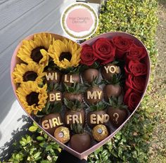 a heart shaped box filled with chocolate covered strawberries and sunflowers that say, will you be my girl friend?