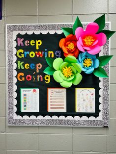 a bulletin board with paper flowers and writing on it that says keep growing, keep going