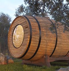 a large wooden barrel sitting on top of a lush green field