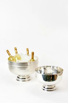 two silver bowls with wine bottles in them