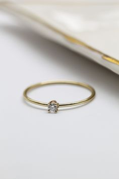 a diamond ring sitting on top of a white table next to a notebook and pen